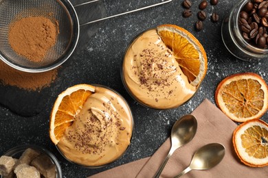 Photo of Glasses of delicious dalgona coffee with ingredients on grey textured table, flat lay