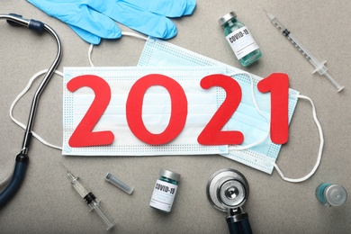 Photo of Flat lay composition with coronavirus vaccine and number 2021 on grey background