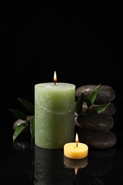 Photo of Composition with candles and spa stones on black background