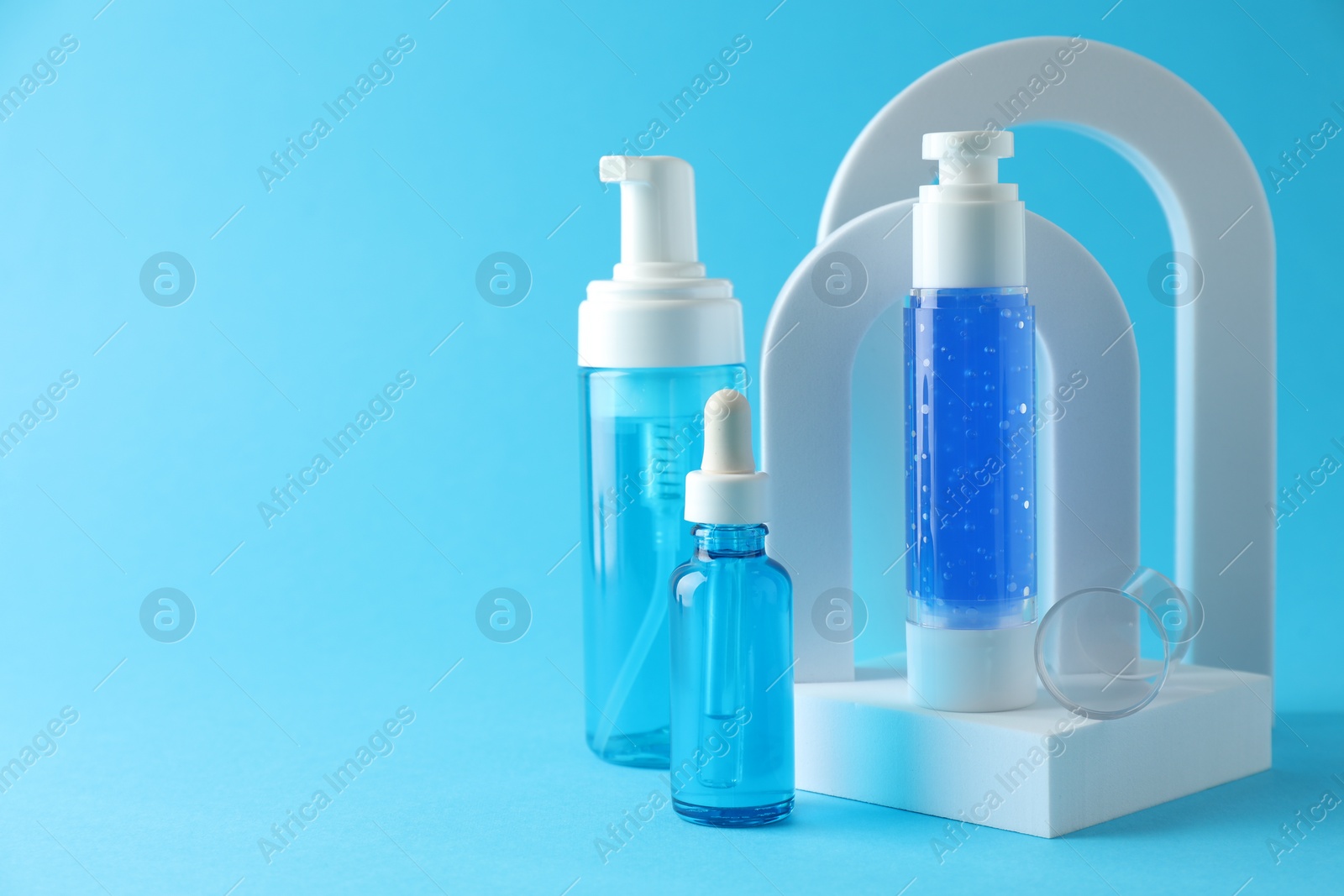 Photo of Stylish presentation of luxury cosmetic products on light blue background. Space for text