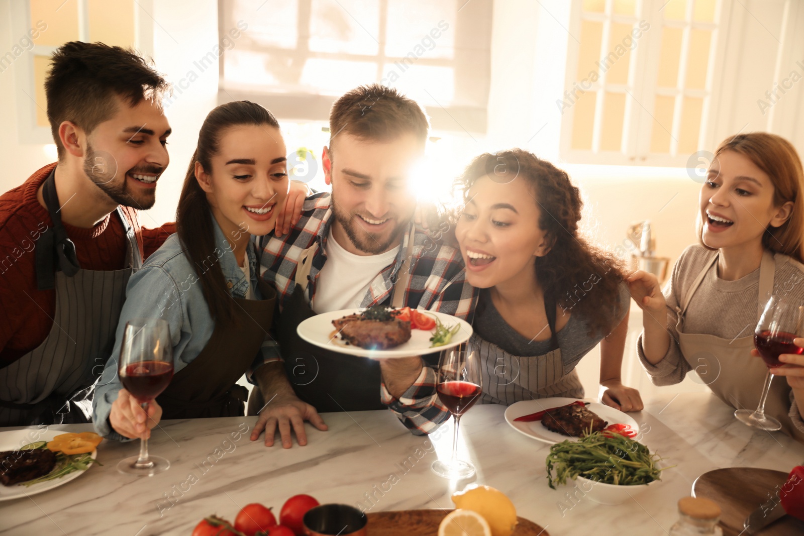 Photo of Happy people with delicious food in kitchen. Cooking class