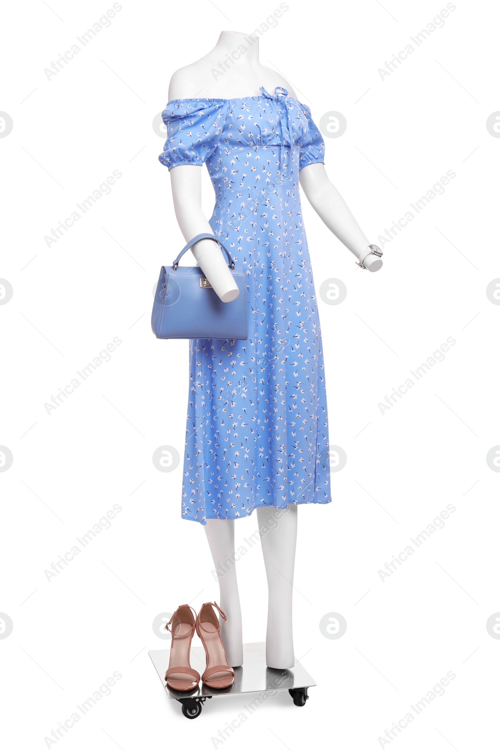 Photo of Female mannequin with accessories dressed in stylish light blue dress isolated on white