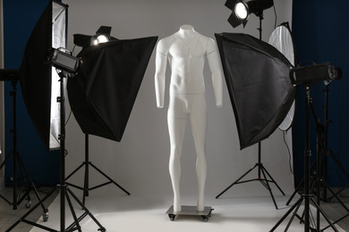 Ghost mannequin and professional lighting equipment in modern photo studio