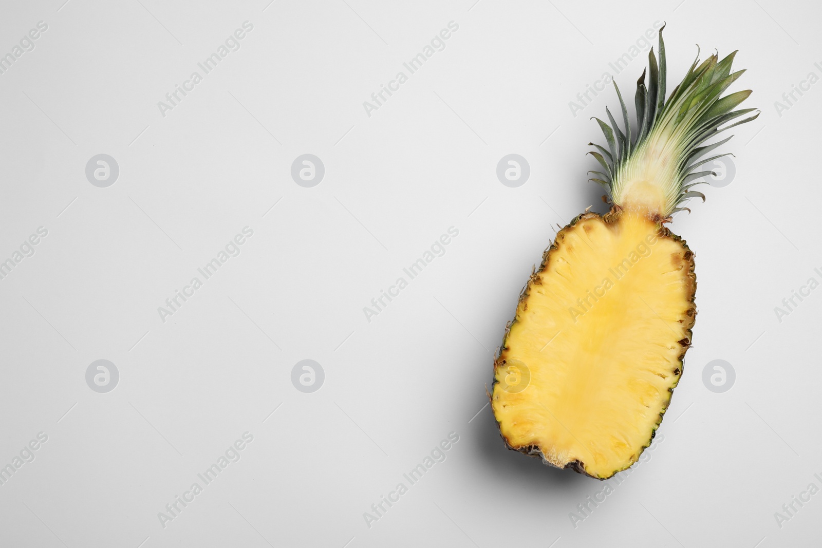 Photo of Half of raw pineapple on white background, top view