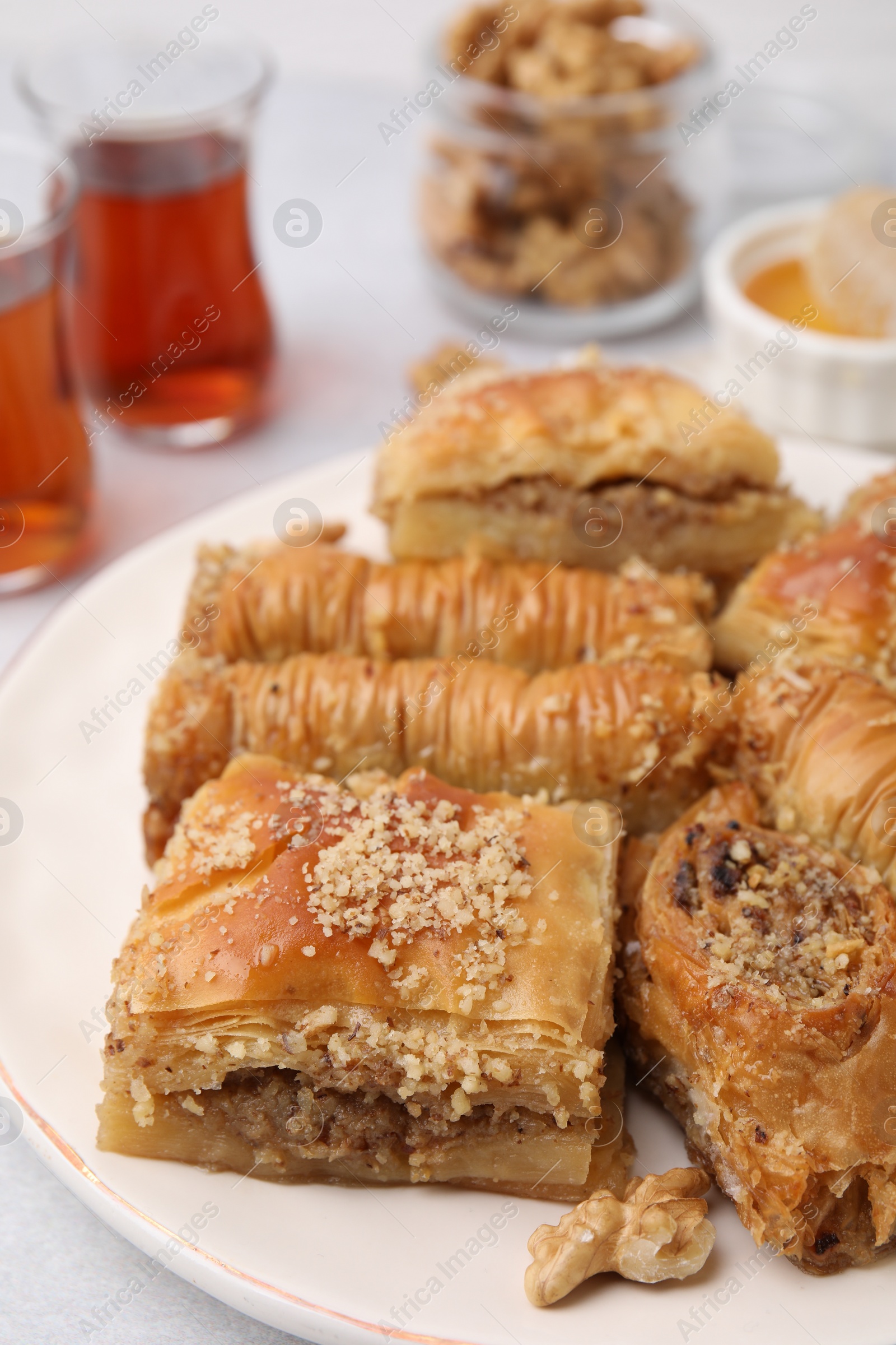 Photo of Eastern sweets. Pieces of tasty baklava on white table, closeup