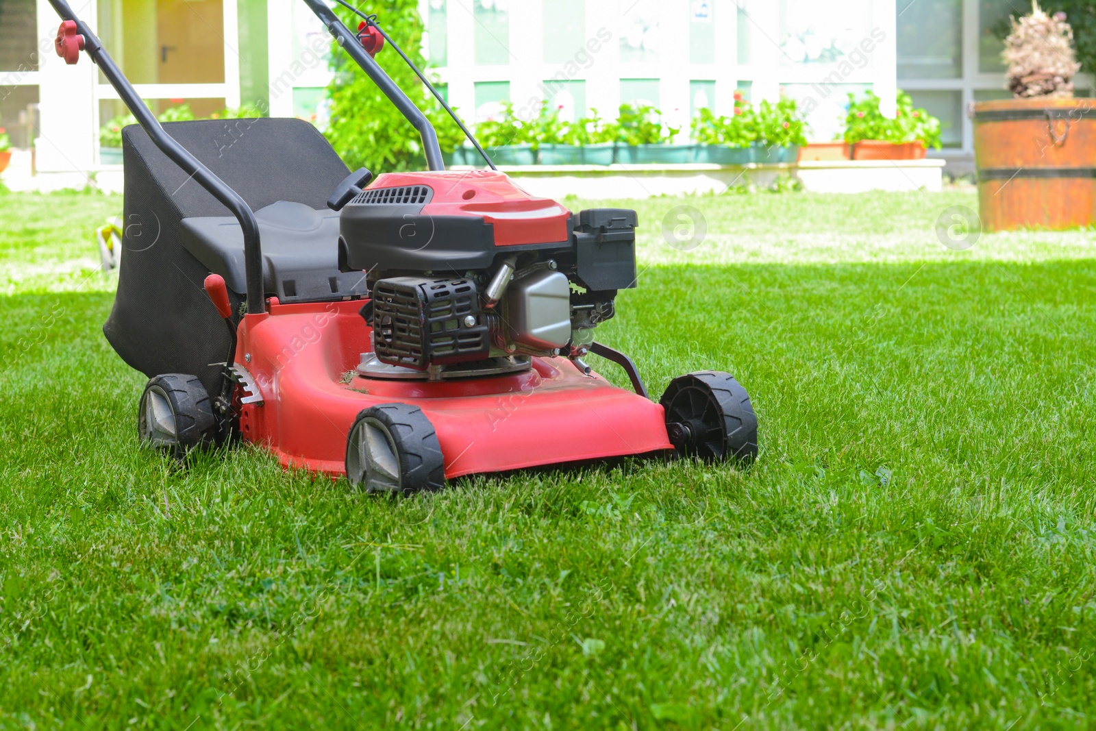 Photo of Modern garden lawn mower on green grass in park