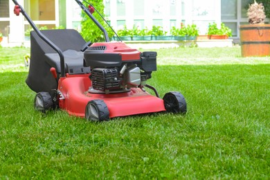 Modern garden lawn mower on green grass in park