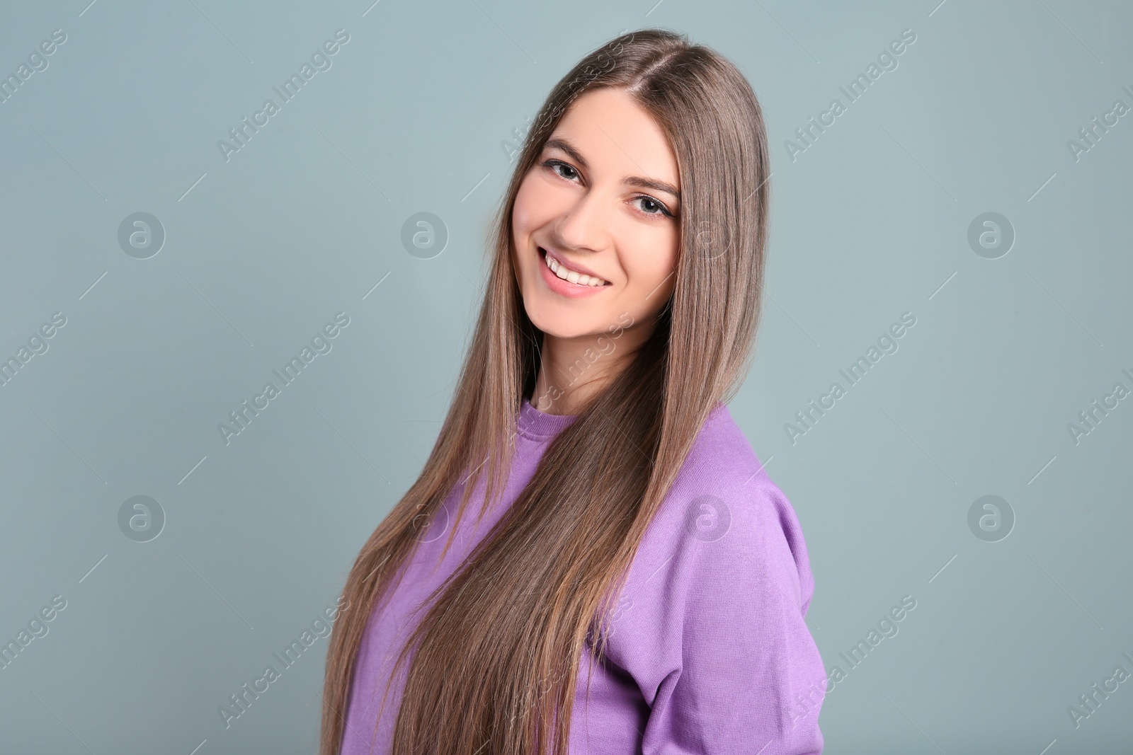 Photo of Portrait of young woman with long beautiful hair on light background