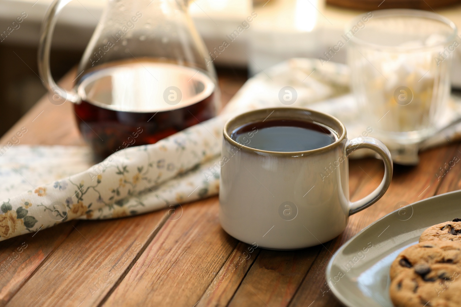 Photo of Mug with delicious tea on wooden table, space for text