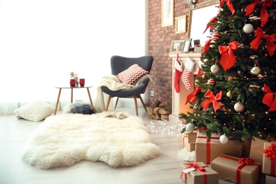 Photo of Room interior with beautiful Christmas tree and gifts near decorative fireplace