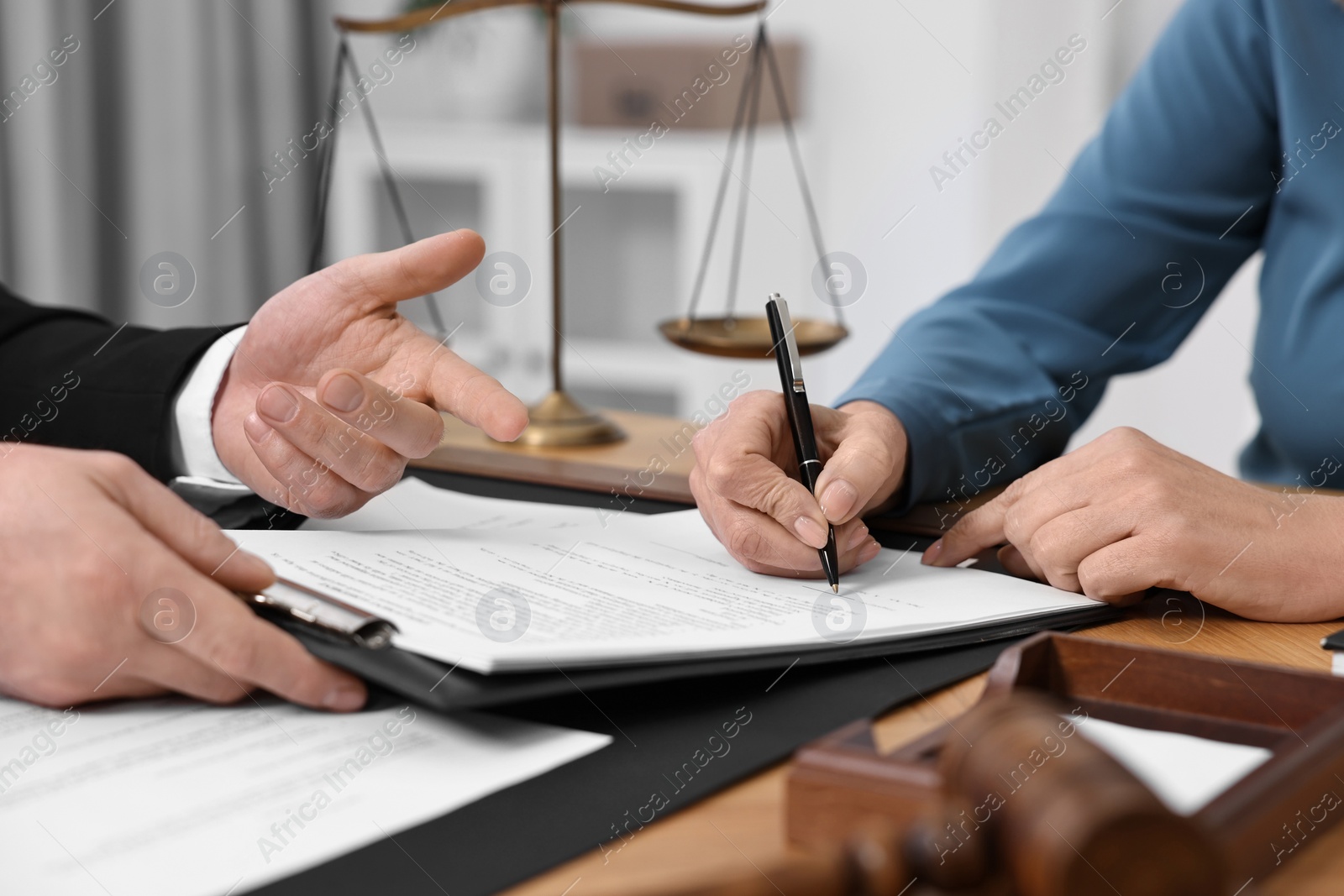 Photo of Senior woman signing document in lawyer's office, closeup