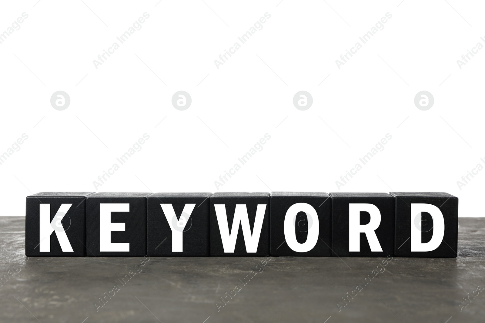 Photo of Black cubes with word KEYWORD on grey table