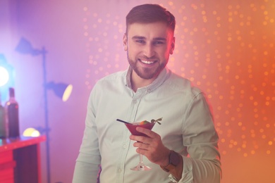 Photo of Young man with glass of martini cocktail at party