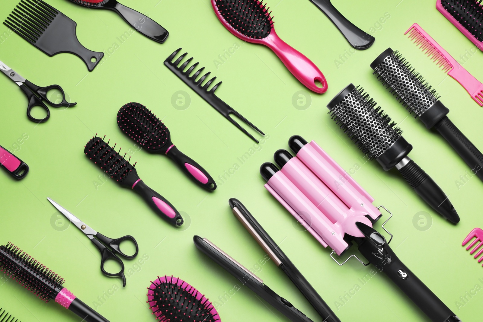 Photo of Flat lay composition of different professional hairdresser tools on light green background