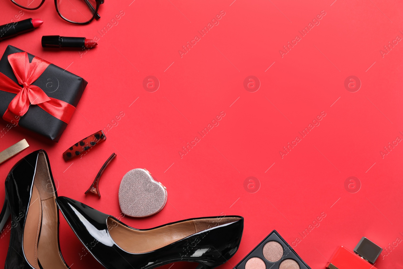 Photo of Female accessories on red background, flat lay. Space for text