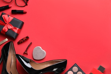 Female accessories on red background, flat lay. Space for text