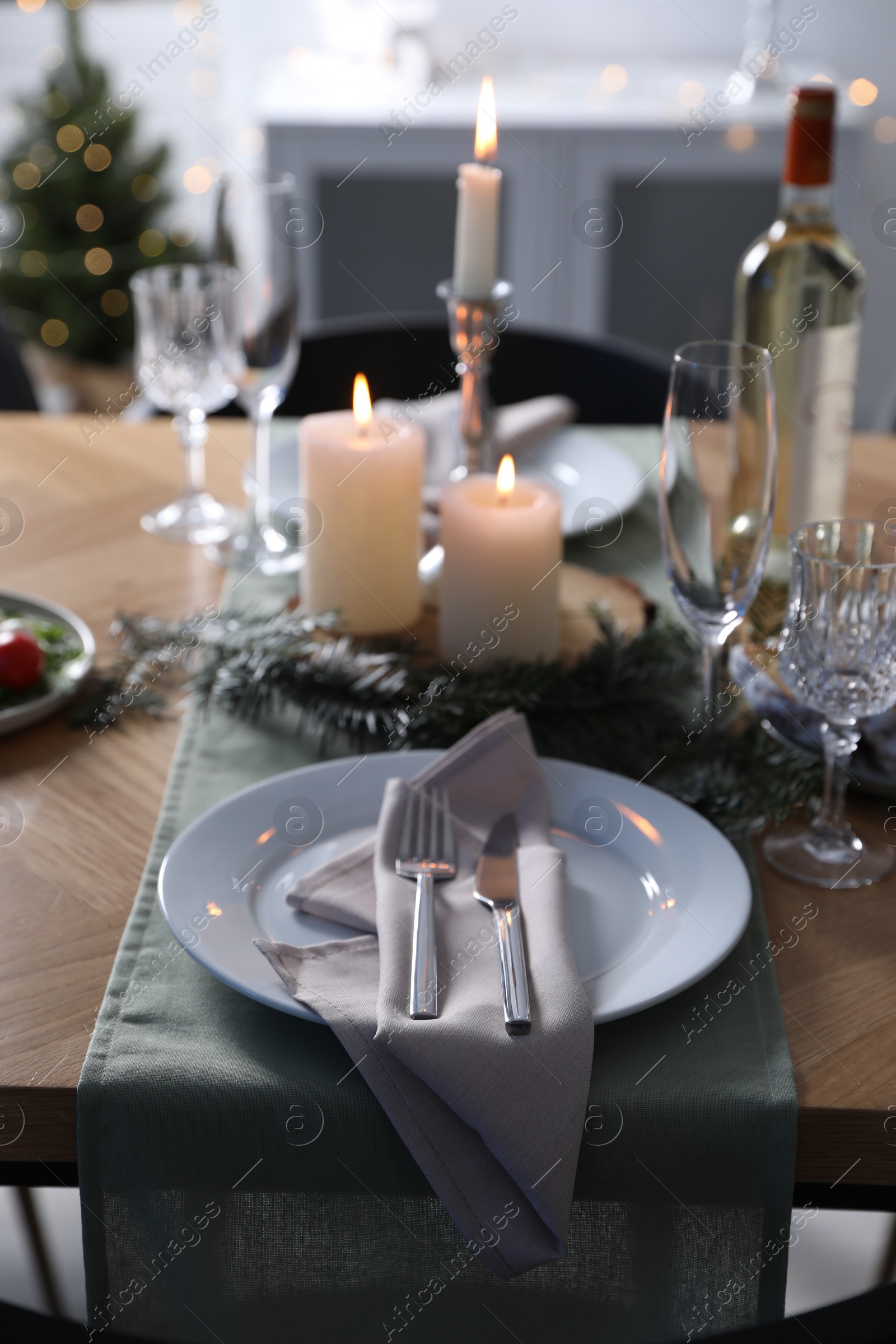 Photo of Christmas table setting with festive decor and dishware indoors