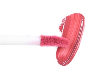 Photo of Stroke of pink lip gloss and applicator isolated on white, top view