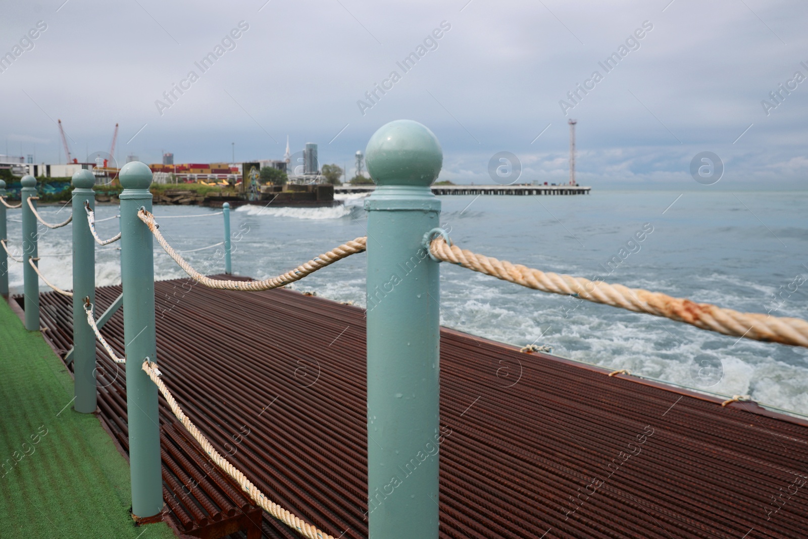 Photo of Picturesque view of sea with waves behind pier fence