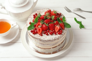 Photo of Delicious homemade cake with fresh berries served on wooden table