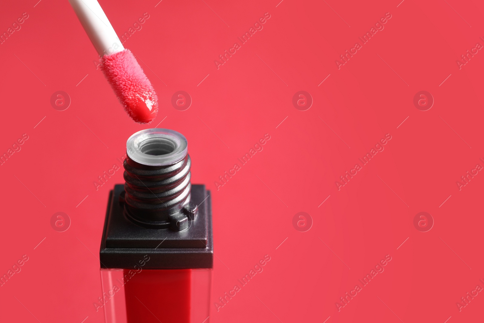 Photo of Applicator above liquid lipstick tube on color background. Space for text