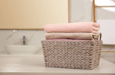 Laundry basket with fresh towels on counter in bathroom