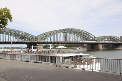 Cologne, Germany - August 28, 2022: Picturesque view of a modern bridge over river and ferry boat