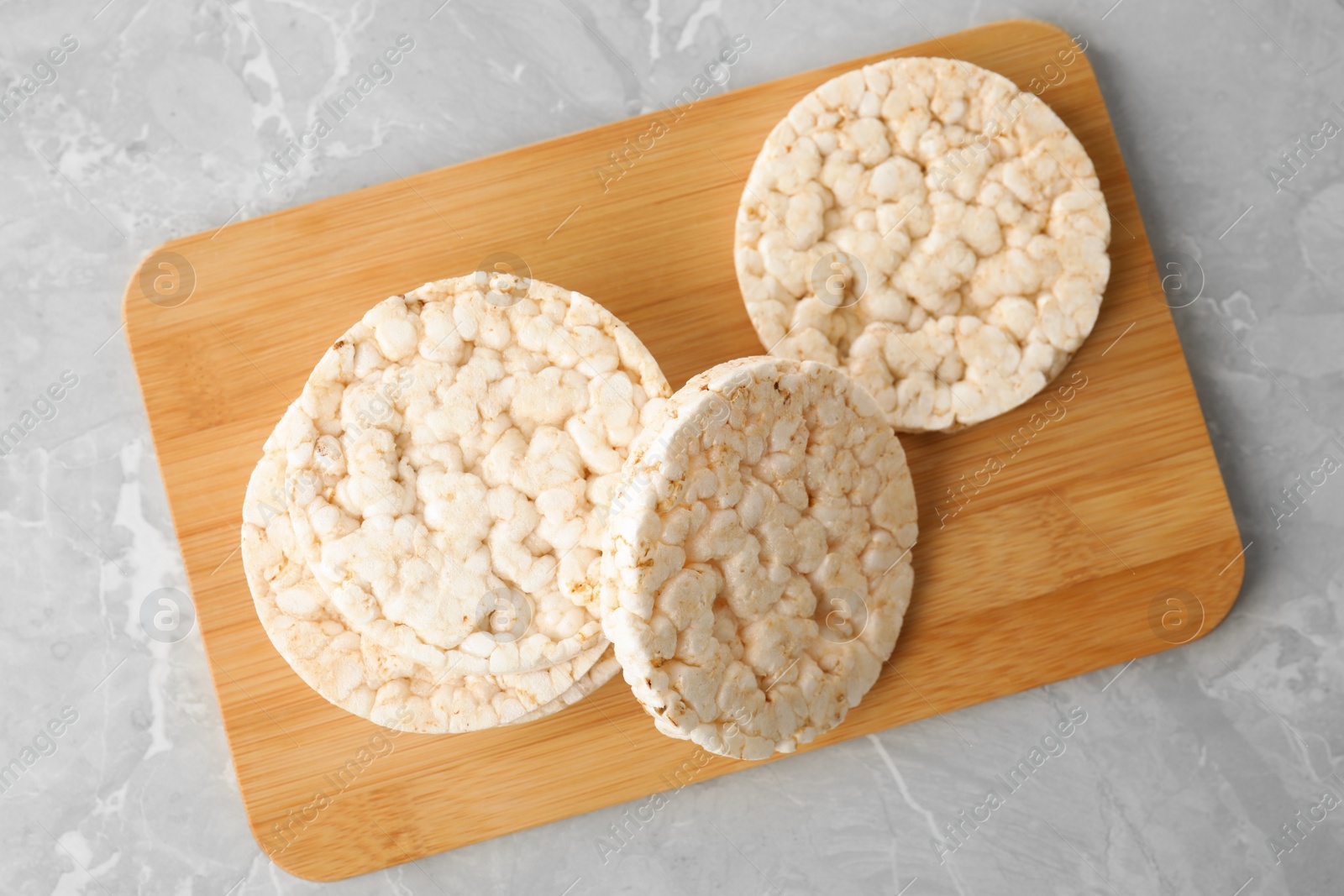Photo of Crunchy rice cakes on grey marble table, top view