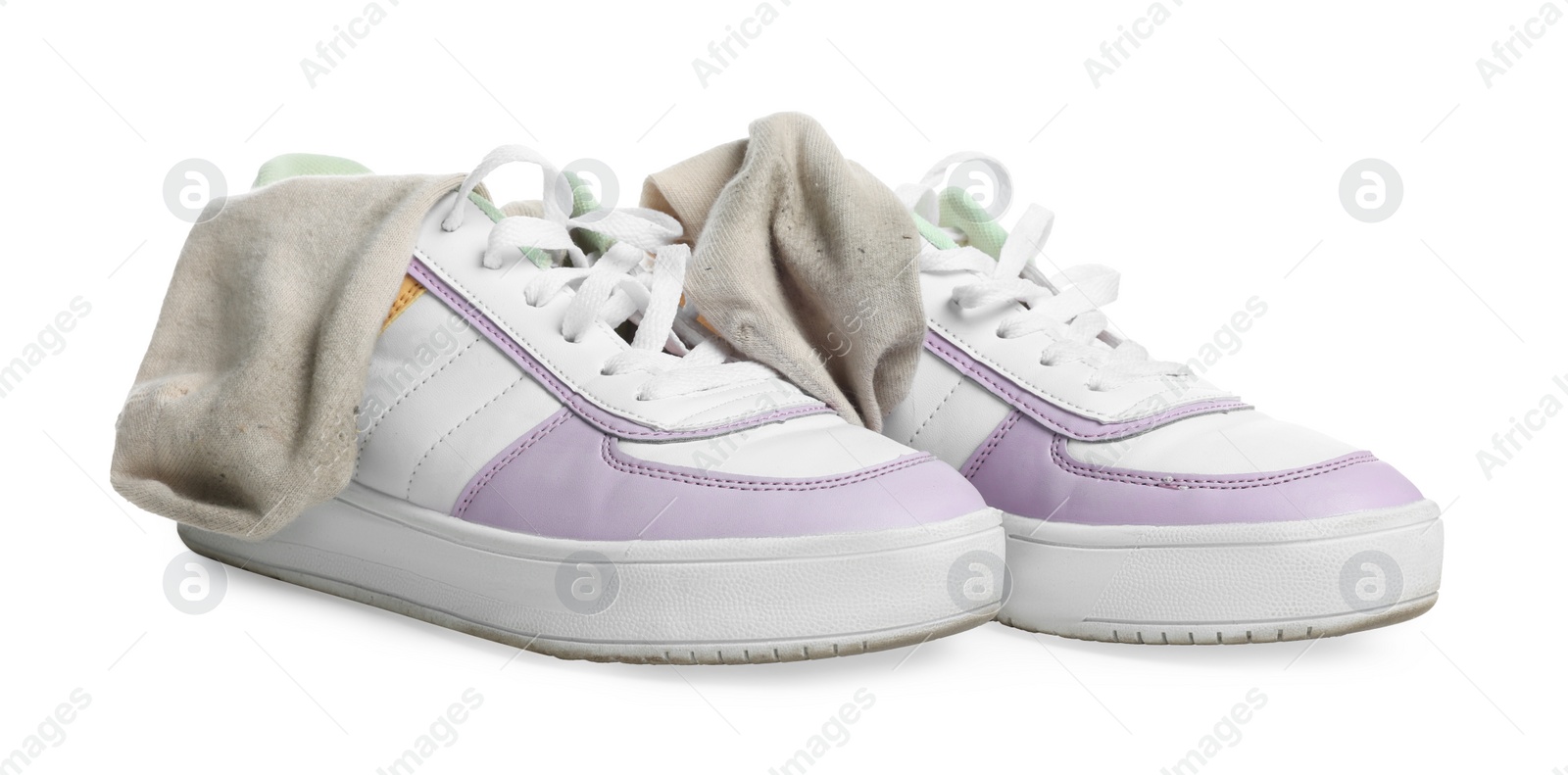 Photo of Dirty socks and sneakers on white background