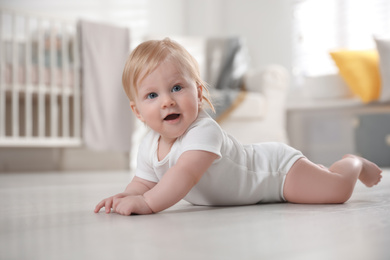 Photo of Cute little baby on floor at home