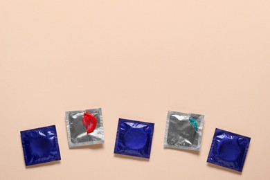 Photo of Condoms on beige background, flat lay with space for text. Safe sex