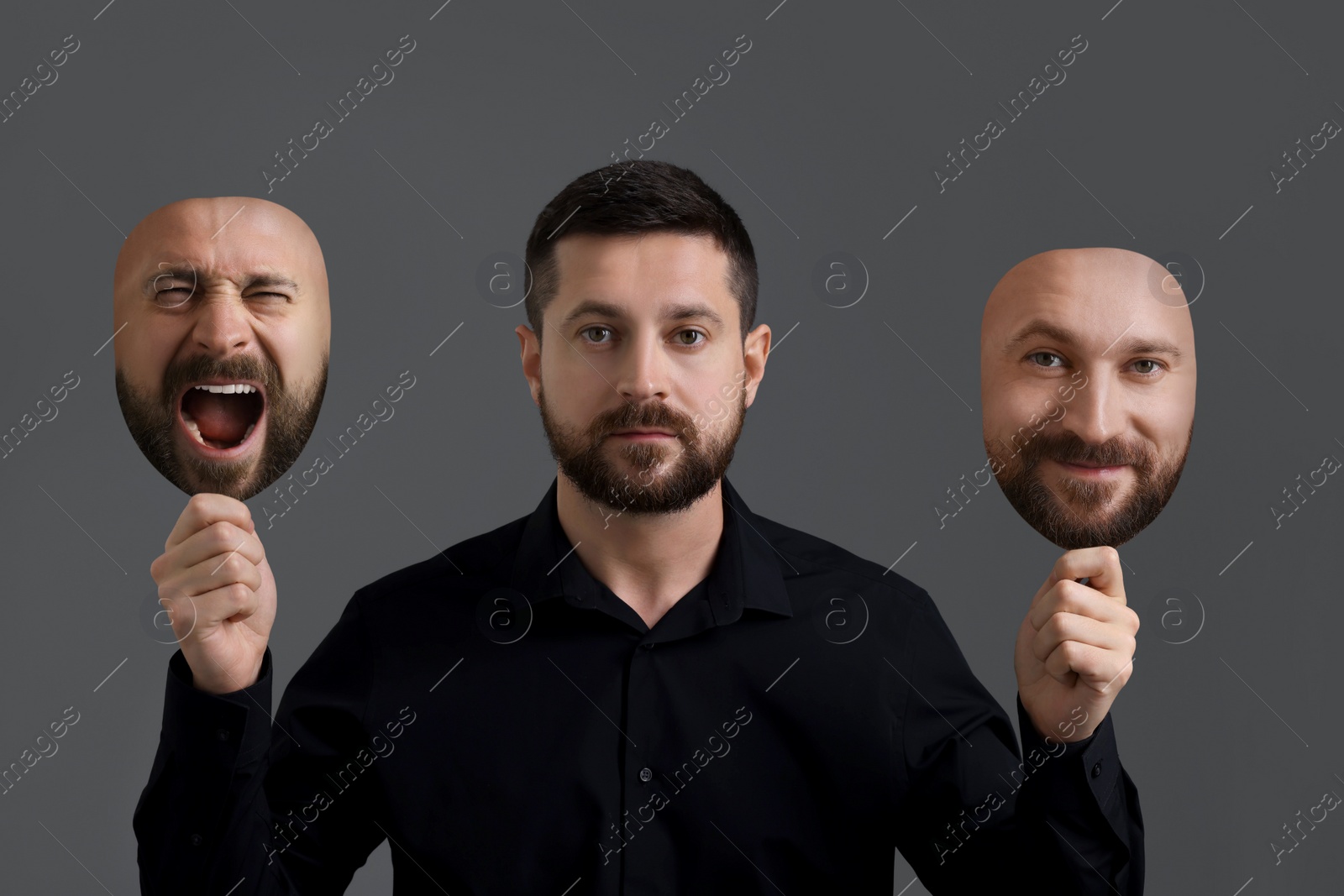 Image of Man holding masks with his face showing different emotions on grey background. Balanced personality