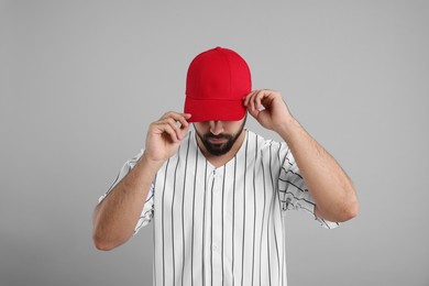 Photo of Man in stylish red baseball cap on light grey background