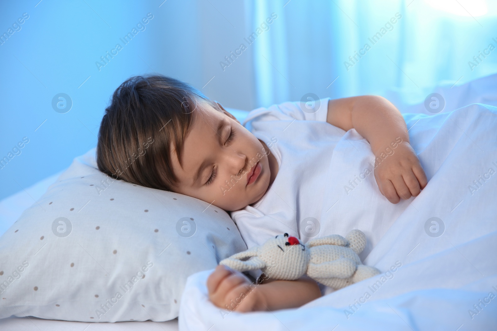 Photo of Cute little baby sleeping with toy at home. Bedtime