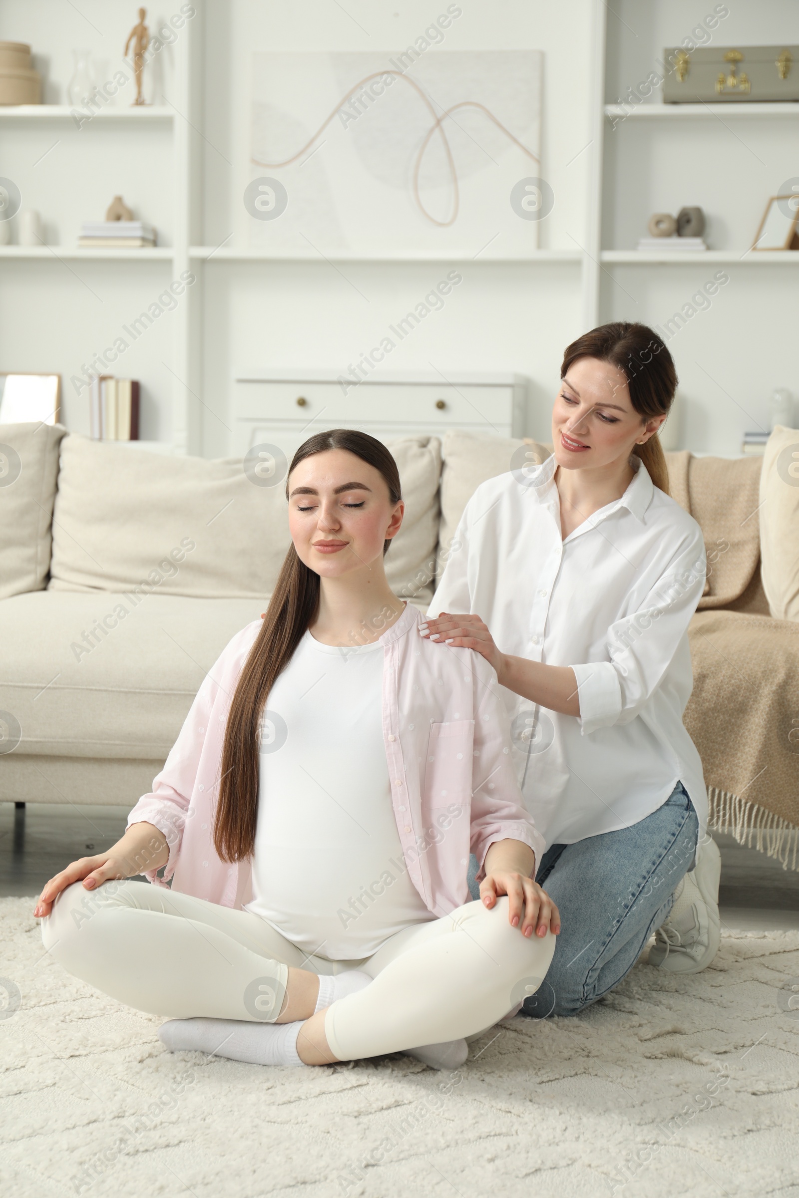 Photo of Doula taking care of pregnant woman at home. Preparation for child birth