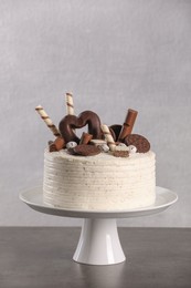Photo of Delicious cake decorated with sweets on grey table