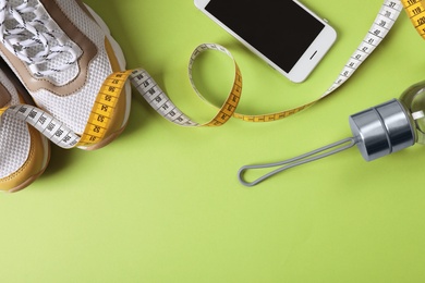 Flat lay composition with fitness gym equipment on color background. Space for text