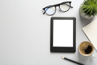 Photo of Flat lay composition with modern e-book reader on white background, space for text