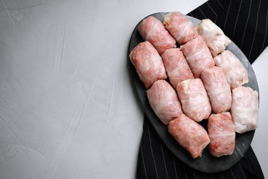 Photo of Uncooked stuffed cabbage rolls on grey table, top view. Space for text