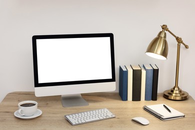 Image of Comfortable workplace at home. Modern computer with blank screen and stationery on wooden desk. Mockup for design