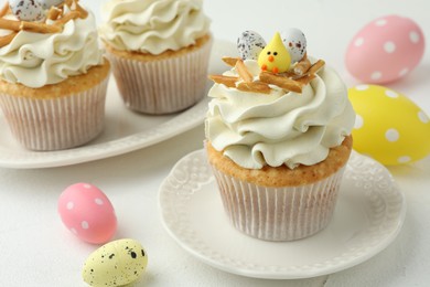 Tasty Easter cupcakes with vanilla cream on white table, closeup