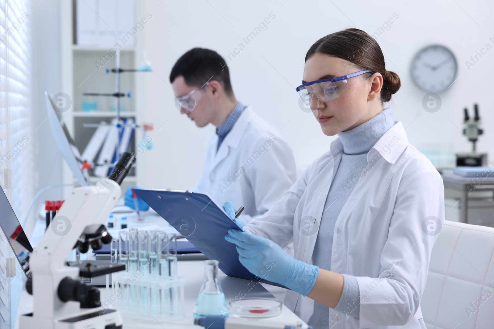 Photo of Scientists working with laboratory test form indoors. Medical research