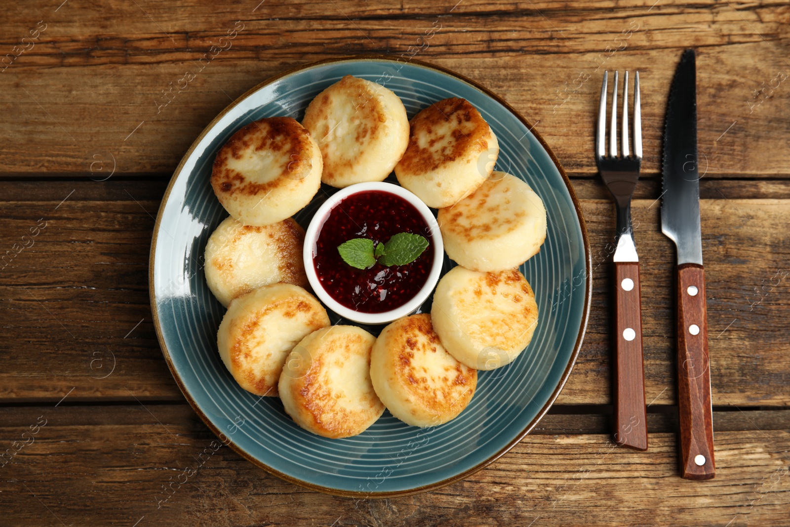 Photo of Delicious cottage cheese pancakes with jam and mint on wooden table, flat lay