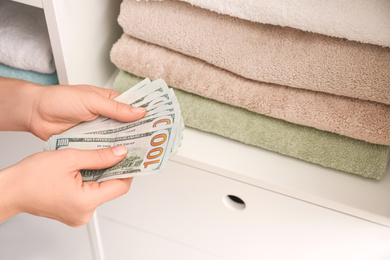 Woman with dollar bills indoors, closeup. Financial savings