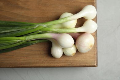 Fresh green onion on wooden board, top view