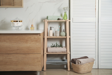 Photo of Shelving unit with toiletries in stylish bathroom interior 