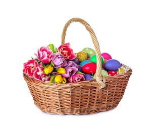 Photo of Wicker basket with bright painted Easter eggs and spring flowers on white background