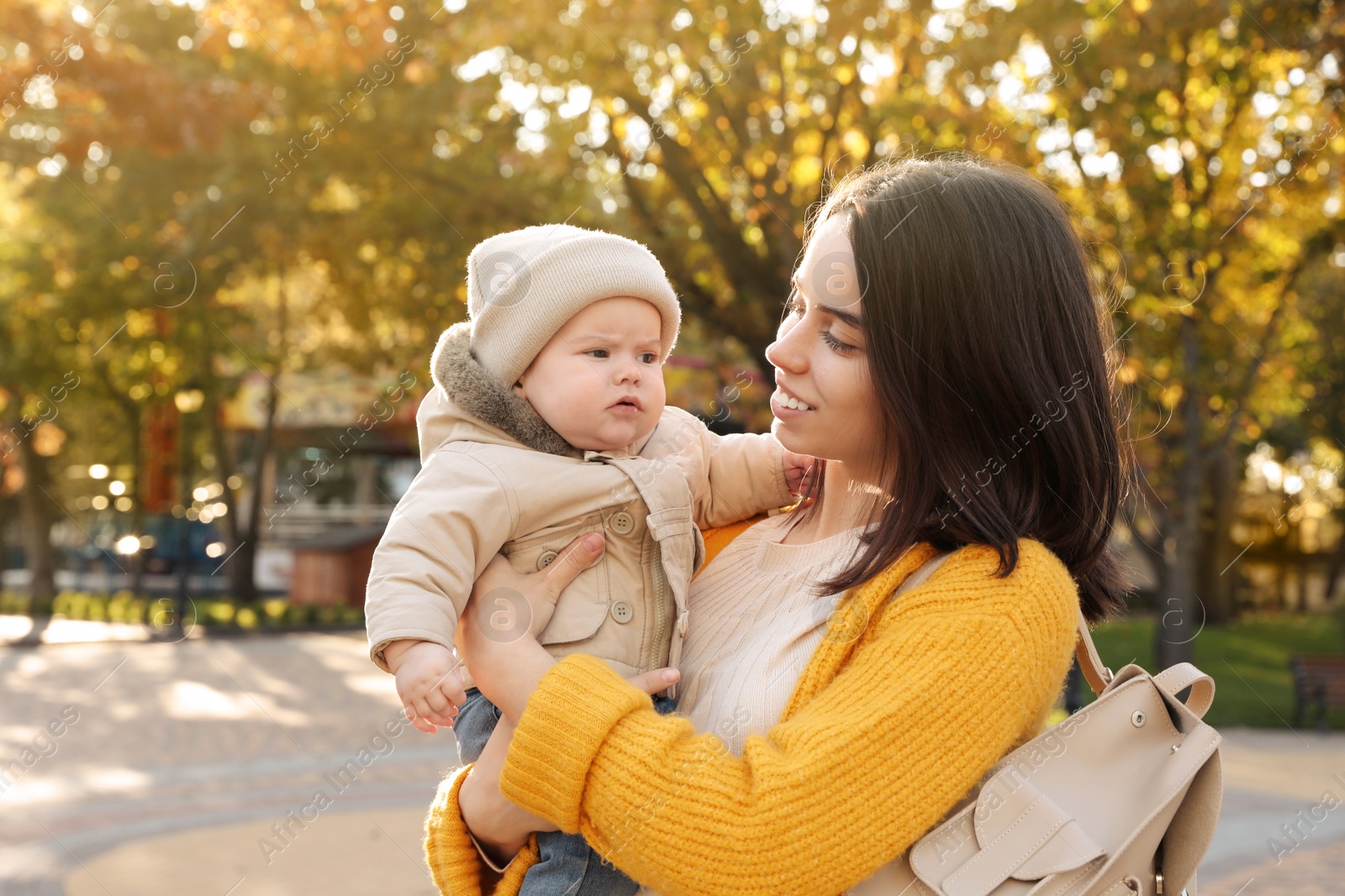 Photo of Happy mother with her baby son outdoors on autumn day