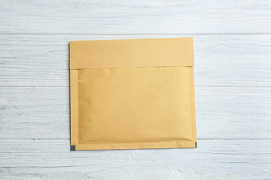 Kraft paper envelope on white wooden background, top view