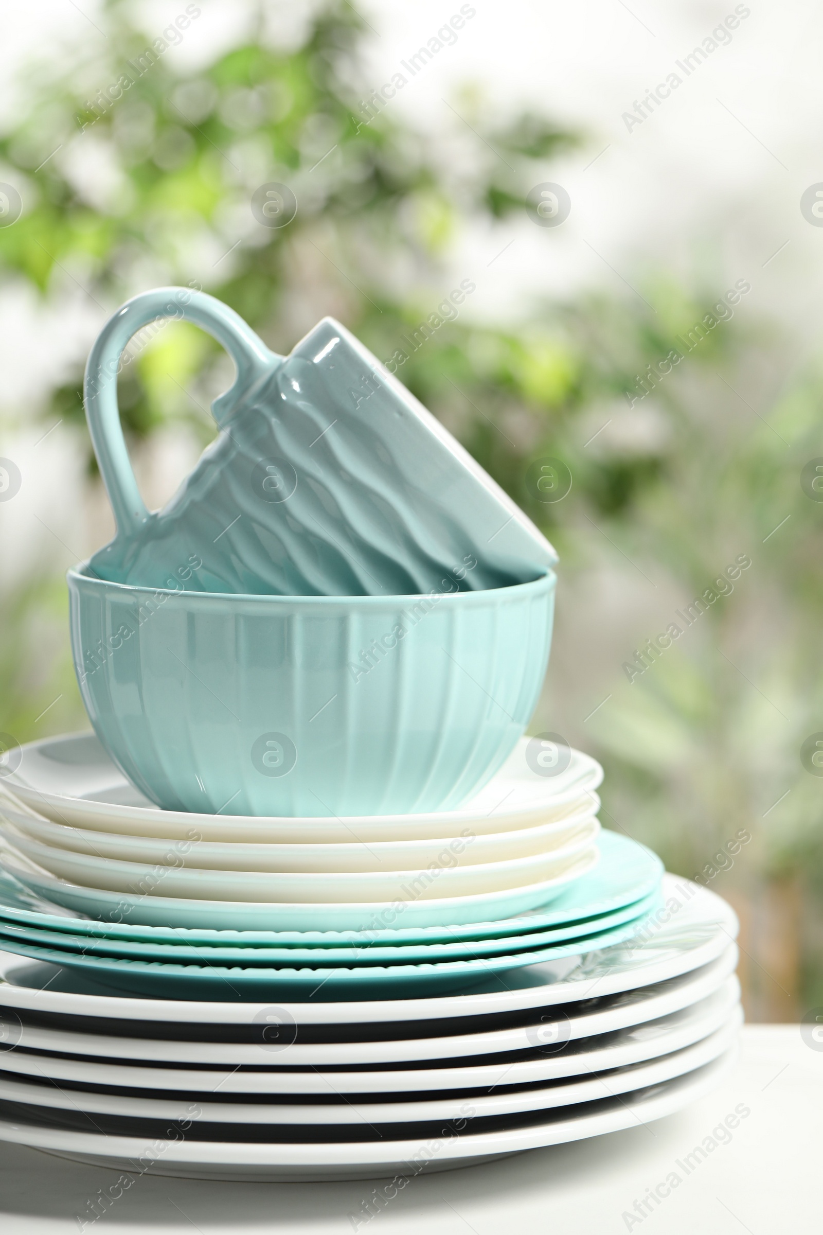 Photo of Beautiful ceramic dishware and cup on white table outdoors